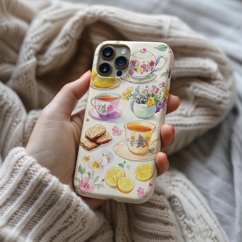 K&ouml;nnte beinhalten: Eine wei&szlig;e iPhone-H&uuml;lle mit einem Aquarell-Design mit Teetassen, Zitronen, Blumen und Keksen. Die H&uuml;lle hat einen Ausschnitt f&uuml;r das Kameraobjektiv und einen wei&szlig;en Hintergrund.