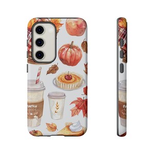May include: A white phone case with a fall-themed design. The design features pumpkins, leaves, pie, and coffee cups. The text "Pumpkin Spice" is visible on one of the coffee cups.
