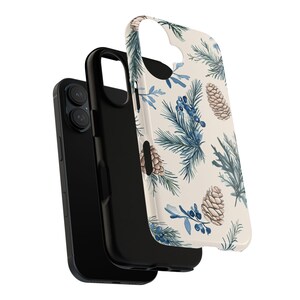 May include: A white phone case with a blue and brown pine cone pattern. The case is shown with a black phone inside.