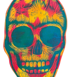 May include: A colorful skull illustration with a teal background and a vibrant mix of yellow, pink, and red. The design features a detailed linocut style, showcasing the skull's features.