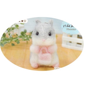 May include: A gray and white felt hamster with a pink felt bag. The hamster is holding the bag in its paws. The hamster is a keychain.