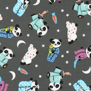 May include: A dark gray fabric with a repeating pattern of pandas wearing pajamas. The pandas are in various poses, some holding stuffed animals, and some are flying through the air. The background is dotted with white stars and crescent moons.