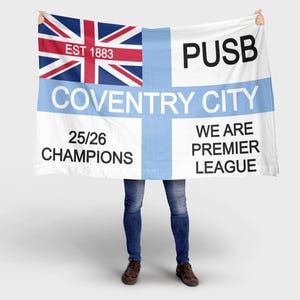 Può includere: Una bandiera bianca con un disegno Union Jack nell'angolo in alto a sinistra e la scritta "EST 1883". La bandiera ha una croce e una striscia orizzontale azzurra con le parole "COVENTRY CITY", "25/26 CHAMPIONS", "WE ARE PREMIER LEAGUE" e "PUSB".