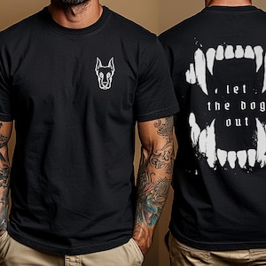 K&ouml;nnte beinhalten: Schwarzes T-Shirt mit einem wei&szlig;en Grafikdruck eines Hundekopfes auf der linken Seite und einem wei&szlig;en Grafikdruck eines Gebisses mit dem Text "let the dog out" auf der rechten Seite.