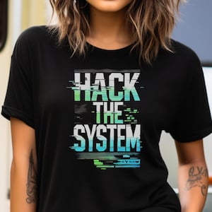 Könnte beinhalten: Schwarzes T-Shirt mit einem Grafikdruck, der "Hack the System" in einer Glitch-Schriftart mit grünen und blauen Akzenten sagt.