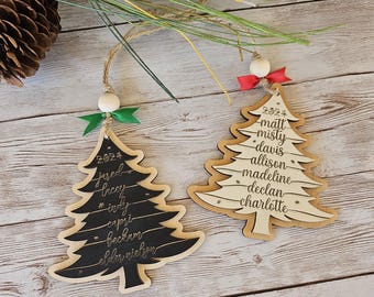 May include: Two wooden Christmas tree ornaments. One is black with names and the year 2024. The other is natural wood with names and the year 2024. Both have twine hangers, wooden beads, and ribbon.