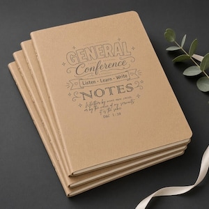 Può includere: Una pila di quattro quaderni color marrone chiaro con angoli arrotondati. La copertina superiore presenta un testo scuro che recita: GENERAL Conference, Listen Learn Write, NOTES, Whether by mine own voice, or by the voice of my servants, it is the same, D&C 1:38.