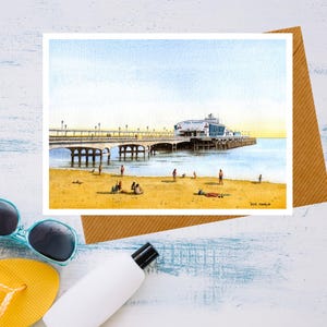 Biglietto d'auguri ad acquerello con paesaggio marino e molo di Bournemouth, interno vuoto, ideale per vacanze al mare.