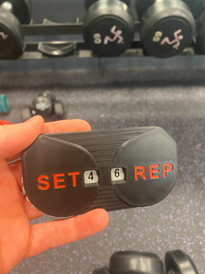 May include: A black plastic counter with red text that reads "SET 4 6 REP".