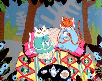 May include: Two cats, one a tiger, are sitting on a pink and red couch with a plaid blanket. They are having tea and are surrounded by a colorful rug and flowers.