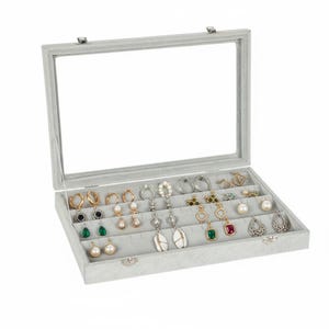 May include: A grey jewellery box with a clear glass lid, displaying an assortment of earrings. The earrings include gold hoops, pearl studs, and gemstone drop earrings. The box is lined with grey fabric and has a silver clasp.