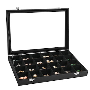 May include: Black jewellery box with a glass lid and 24 compartments for storing earrings. The box is open and filled with various earrings.