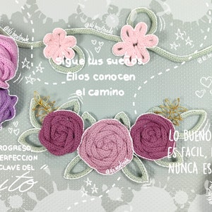 May include: An artistic composition featuring handmade floral designs and yarn balls in shades of pink, purple, and green. The image includes text in Spanish: "Sigue tus sue&ntilde;os, Ellos conocen el camino" and "Lo bueno nunca es facil, lo facil nunca es bueno."
