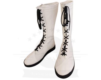 May include: A pair of white wrestling boots with black laces. The boots are made of canvas and have a thick rubber sole.