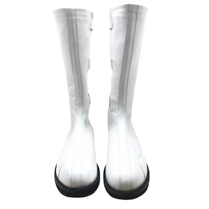 May include: A pair of white leather knee-high boots with black soles.