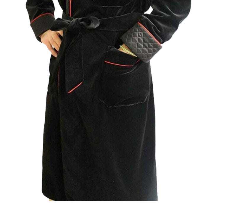 May include: A black velvet robe with red piping and a matching black velvet belt. The robe has a patch pocket on the left side.