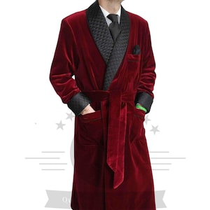 May include: A long, red velvet robe with a black quilted shawl collar and a matching sash. The robe has long sleeves and two pockets.