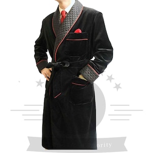 May include: A black velvet robe with red piping and a quilted collar. The robe has a sash tie and two pockets.
