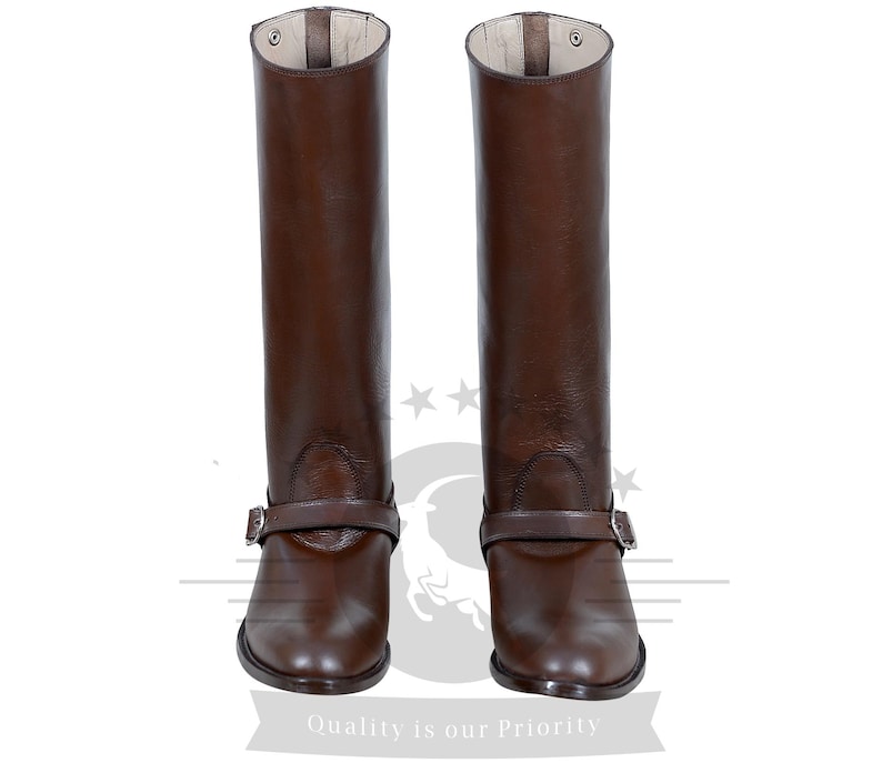 May include: A pair of brown leather riding boots with a buckle strap. The boots have a pointed toe and a tall shaft.