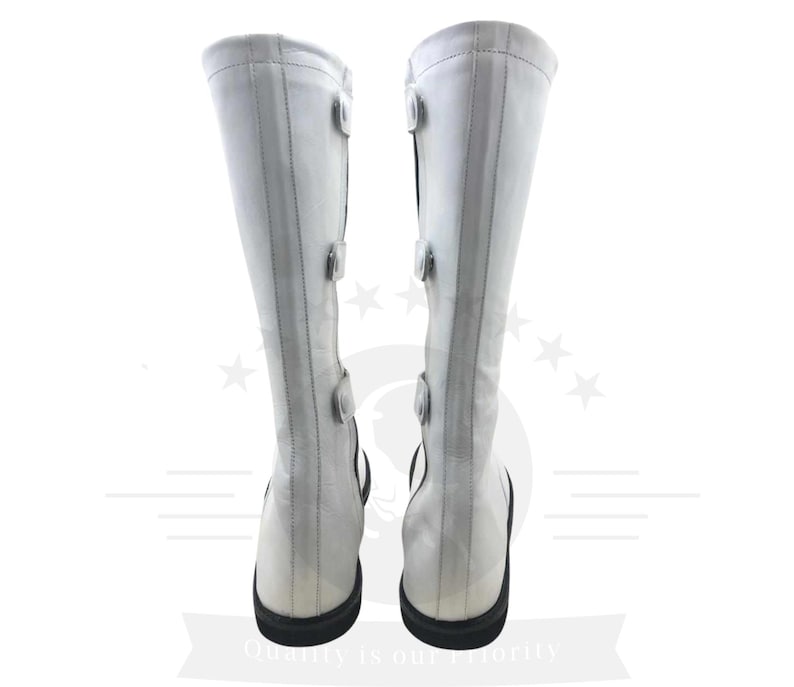 May include: A pair of white leather knee-high boots with black buckles and a black heel.