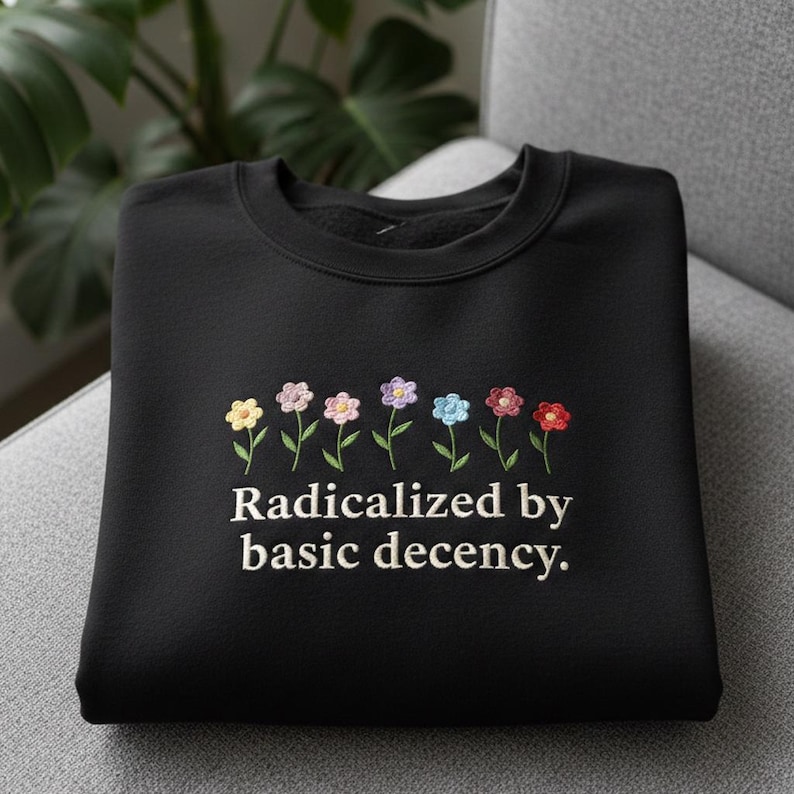 May include: A white ceramic mug with a black handle and the text "But First, Coffee" in a bold, black font. The mug is set against a neutral background, highlighting its simple design.