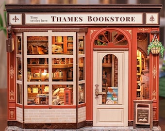 May include: Miniature model of the Thames Bookstore, featuring a red and white facade with a sign that reads "Thames Bookstore." The model includes a detailed interior with bookshelves, a red telephone booth, and a small sign that reads "Open the door and meet another world."