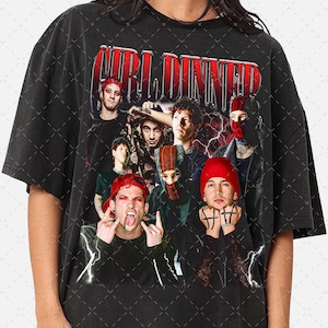 May include: Black t-shirt with a graphic of a group of people, red accents, and the word "WORLDINNER" in red. The design includes lightning bolts and a grunge aesthetic. The people in the image are wearing hats and face coverings.