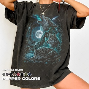 Puede incluir: Camiseta gris oscuro con un gráfico detallado de lobos aullando a la luna. El diseño incluye una luna llena, un cielo estrellado y una escena de bosque. El texto "PEPPER COLORS" se muestra en la parte inferior, con una paleta de colores encima.