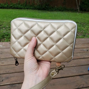 Cartera de viaje de un día acolchada metalizada dorada con correa para la muñeca