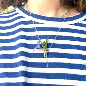 Pingente de mão segurando flor em prata de lei