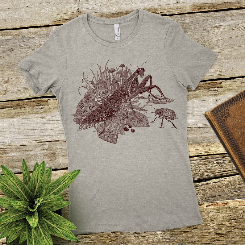 Praying mantis and friends printed on a Next level heather gray tshirt 90percent cotton 10 percent polyester. Also available on a cream next level tshirt whichis 100 percent cotton.