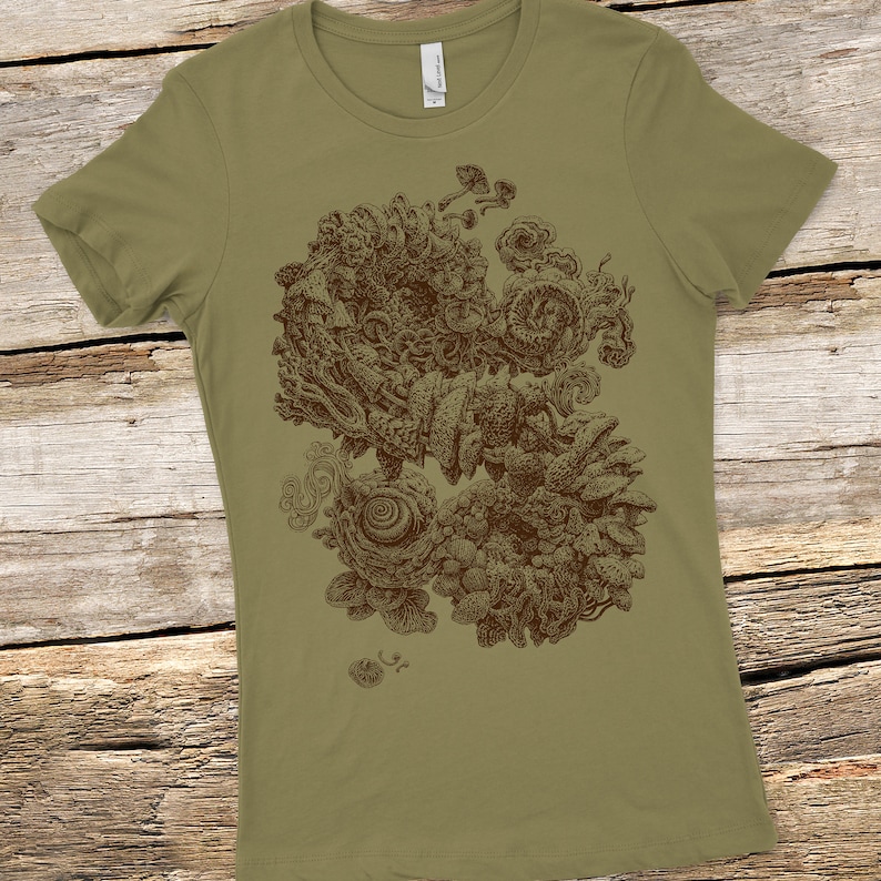 Op de afbeelding: Olijfgroen t-shirt met een gedetailleerde bruine illustratie van een abstract, organisch ontwerp. Het kunstwerk bevat wervelende vormen, paddenstoelachtige vormen en ingewikkelde texturen, waardoor een complex patroon ontstaat. Het shirt is gemaakt van zacht materiaal.