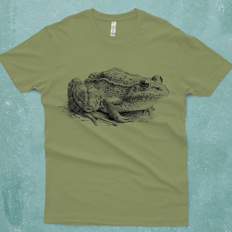A detailed hand drawn frog screen printed onto a unisex-mens 100% cotton light olive Next Level brand tshirt.