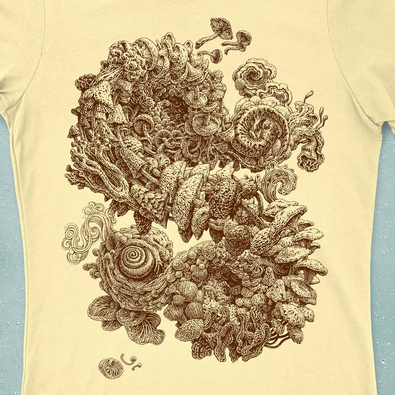 Op de afbeelding: Lichtgeel T-shirt met een sepia-kleurige illustratie van paddenstoelen en organische vormen. Het ontwerp heeft complexe texturen en wervelende patronen. Het kunstwerk roept een natuurlijk, fantasierijk thema op, met gedetailleerde lijnen.