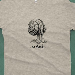 A Snail shell with human feet sticking out of the bottom. The caption reads "no thanks". It's printed with black ink on a heather gray shirt.