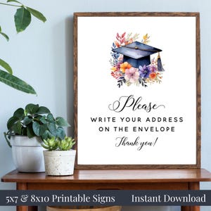 May include: A framed graduation sign featuring a blue mortarboard and floral watercolor art. The sign says "Please write your address on the envelope. Thank you!" and is available as a printable download, with 5x7 and 8x10 sizes.