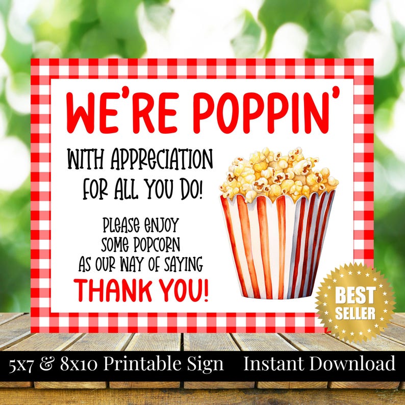 Op de afbeelding: Een printbaar bord met een rood-witte geruite rand. Het bord luidt "WE'RE POPPIN'" en bevat de tekst "WITH APPRECIATION FOR ALL YOU DO! PLEASE ENJOY SOME POPCORN AS OUR WAY OF SAYING THANK YOU!" Een aquarel illustratie van popcorn in een gestreepte bak is ook aanwezig.
