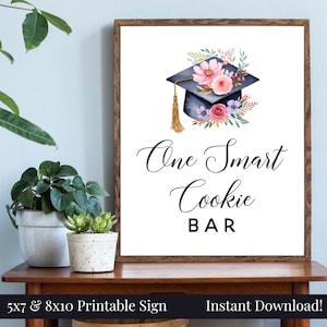 May include: Printable sign with a graduation cap decorated with pink and purple flowers. The text reads "One Smart Cookie Bar".
