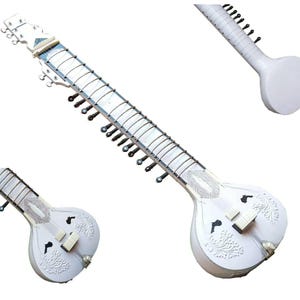 May include: A white sitar, a long-necked stringed instrument, with a rounded body and a long, straight neck. The sitar has multiple strings and tuning pegs. The body features ornate carvings. The image includes multiple views of the instrument.