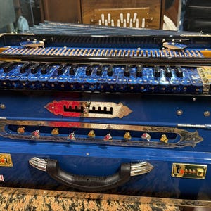 以下が含まれることがあります： 黒い持ち手と「But First, Coffee」のテキストが黒い太字で書かれた白いセラミックマグ。マグカップは無地の白い背景に置かれています。マグカップの高さは約10cmです。