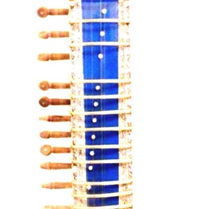 May include: A blue sitar, a long-necked stringed instrument, with intricate silver-colored detailing. The instrument features a rounded body and a long neck with frets and tuning pegs. The sitar is a traditional instrument used in Indian classical music.