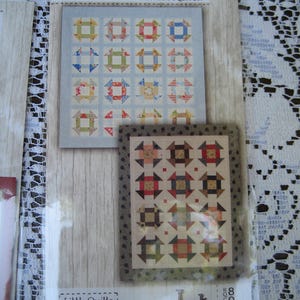 May include: A package featuring two quilt patterns. The top pattern has a light blue background with colorful square quilt blocks. The bottom pattern has a beige background with square quilt blocks. The text "Little Bites" and "Jot" are visible.