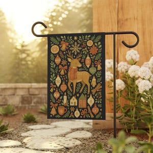 May include: A decorative garden flag featuring a festive design. The flag showcases a deer wearing a scarf, surrounded by Christmas ornaments, houses, and other holiday-themed elements. The background is a dark navy blue.