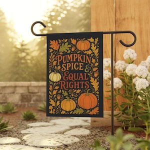 May include: Black garden flag with the text "PUMPKIN SPICE & EQUAL RIGHTS" in orange and gold lettering. The flag features illustrations of pumpkins, leaves, and acorns in shades of orange, yellow, and green.