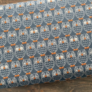 May include: A blue fabric with a white owl pattern. The owls have orange beaks and feet.