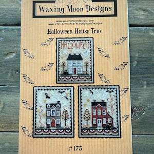 May include: A tan paper pattern booklet titled Waxing Moon Designs Halloween House Trio #175. The cover features three cross-stitch patterns of houses with Halloween themes, including bats, ghosts, and the words Halloween, Tricks, and Treats.