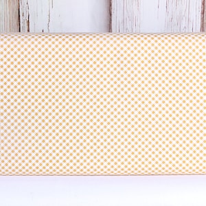 May include: White fabric with a small, yellow gingham pattern.