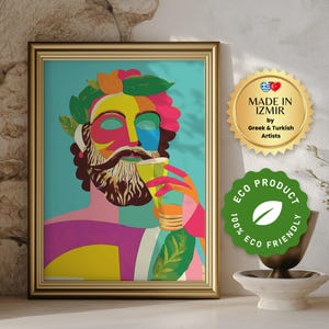 Op de afbeelding: Een kleurrijke, abstracte illustratie van een persoon met een baard die uit een glas drinkt. Het kunstwerk is in goud ingelijst en heeft een blauwe achtergrond met groene bladeren. De tekst "MADE IN IZMIR by Greek & Turkish Artists" is zichtbaar in de rechterbovenhoek.