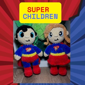 May include: Two handmade crochet dolls dressed as superheroes. One doll has black hair, and the other has blonde hair. Both dolls wear blue and red costumes with a yellow emblem. The dolls are standing in front of a background with the text "SUPER CHILDREN".