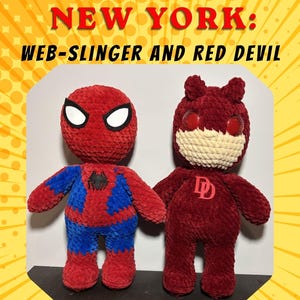 May include: Two plush dolls featuring a red and blue character with a black spider emblem and white eyes, and a dark red character with a cream-coloured lower face, red eyes, and a red double D emblem. Text reads: DEFENDERS OF NEW YORK: WEB-SLINGER AND RED DEVIL BY: NATHAN - VV'S STITCHES.